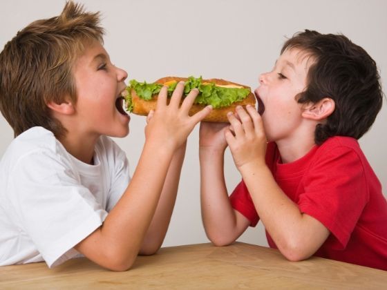 Foto van wee kinderen die samen een broodje moeten verdelen, metafoor voor het verdelen van de erfenis